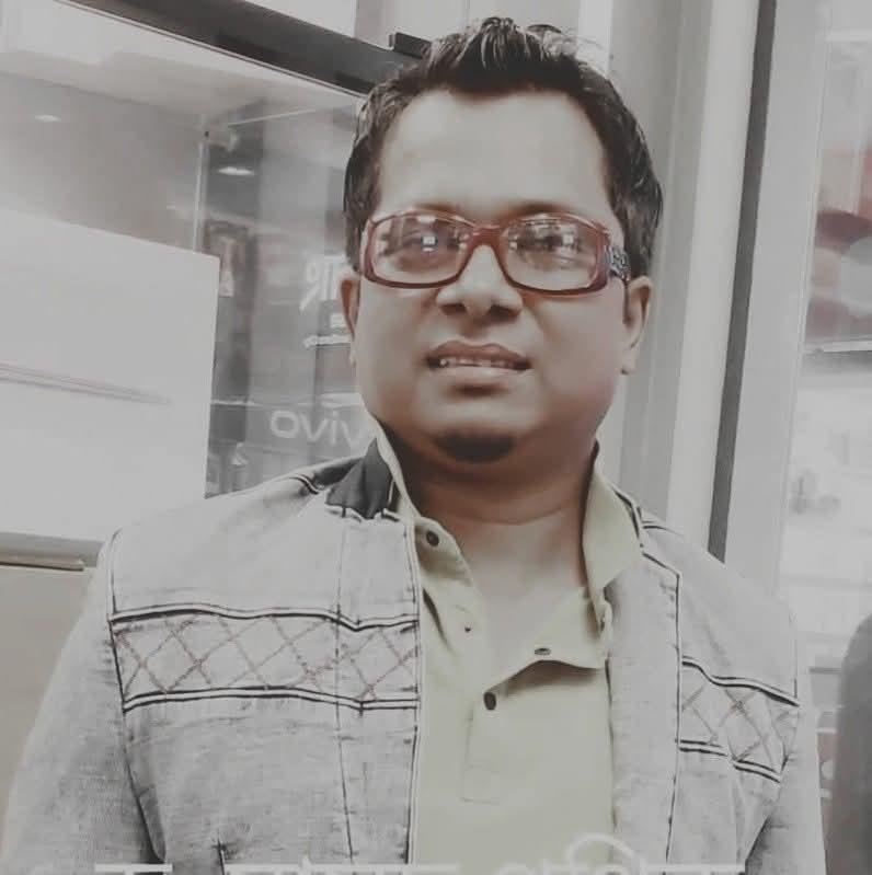 Portrait of Masud Pathik in red-framed glasses