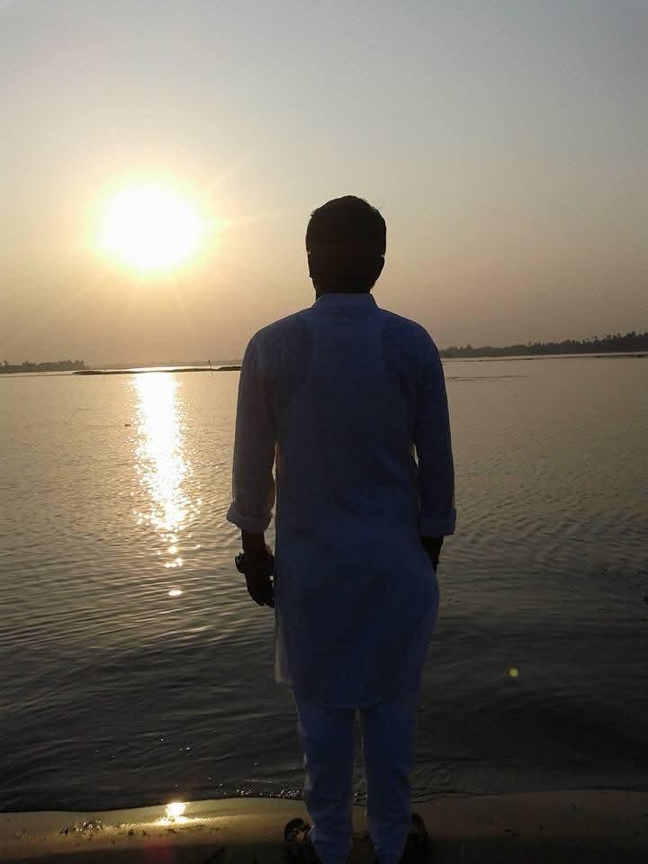Masud Pathik from behind at the river at sunset